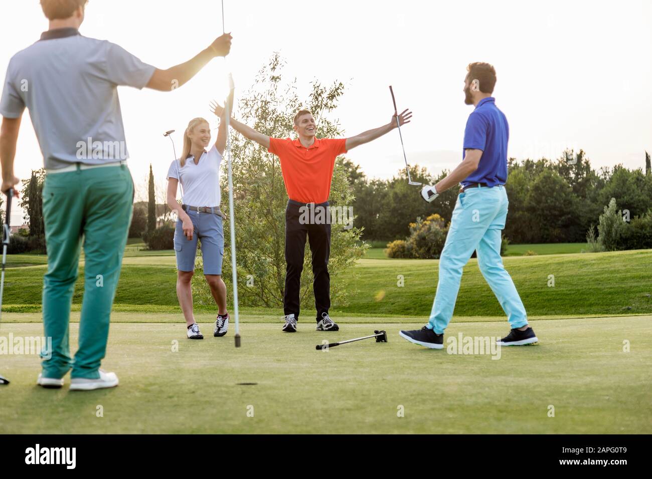 Freunde, die auf dem Golfplatz Golf spielen Stockfoto