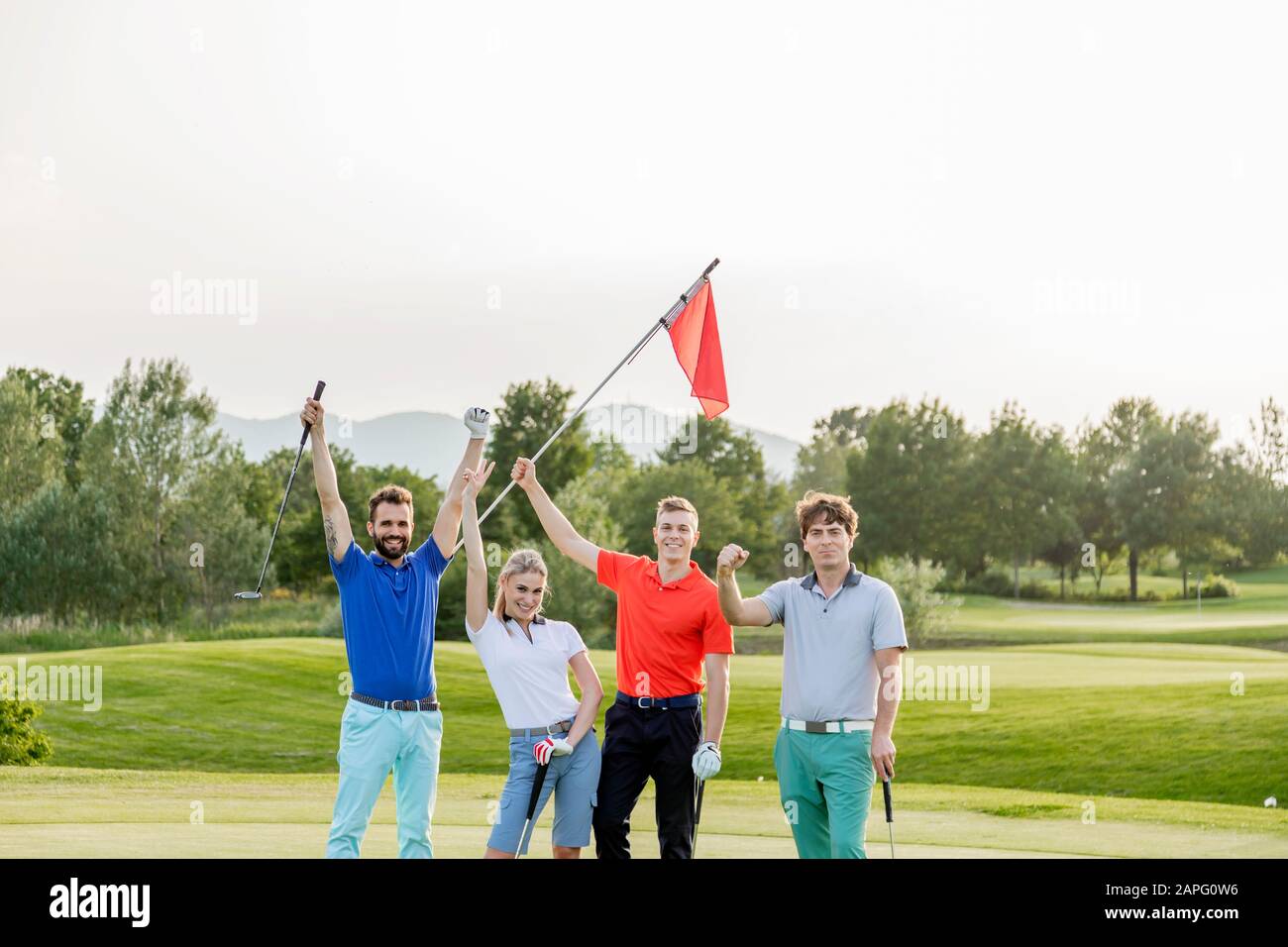 Freunde winken Flaggstick auf dem Golfplatz Stockfoto