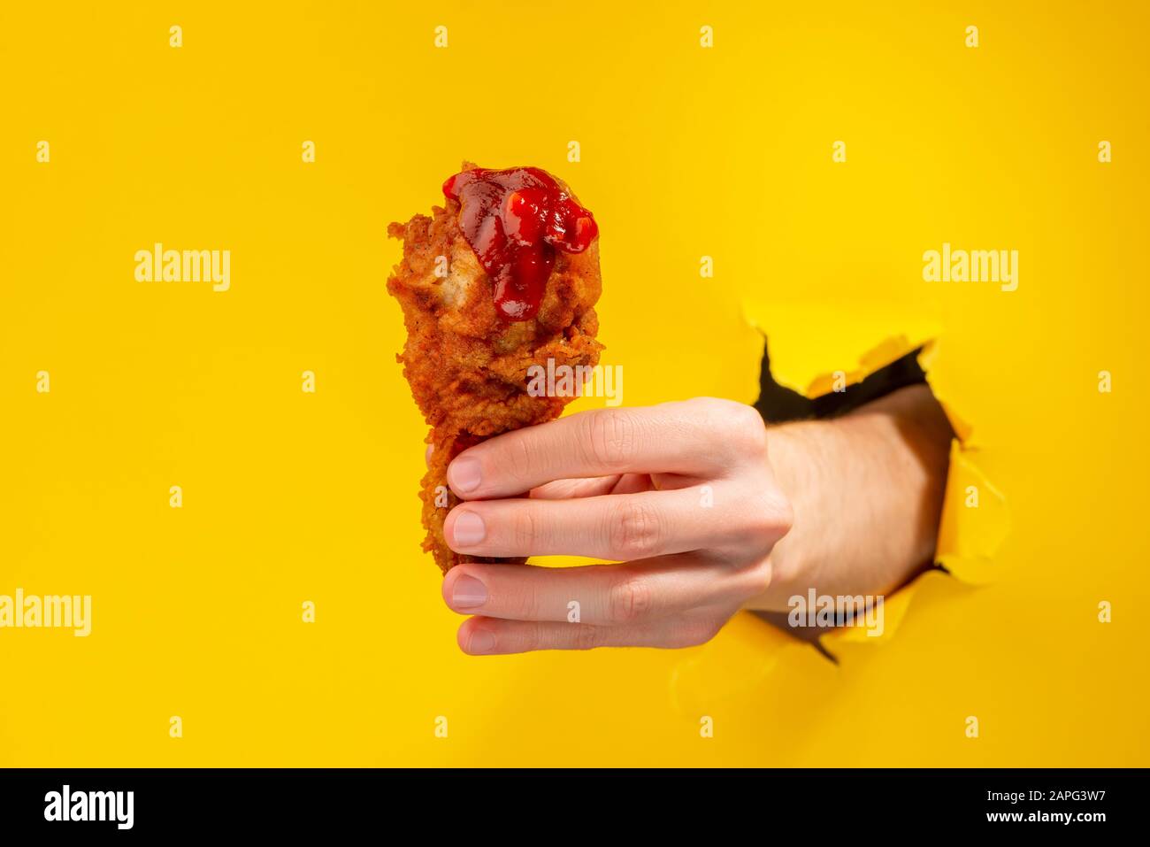 Frittierter Hähnchentrommelstab. Hand, die den Snack anbietet Stockfoto