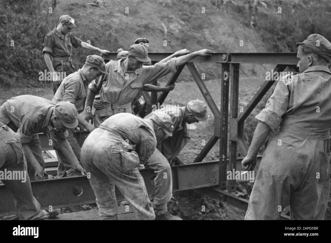 Sektor Cheribon (1. Polizeiaktion 21./27. Juli 1947) Beschreibung: Cheribon-Sektor: Auf ihrer Flucht sprengten republikanische Truppen unzählige große und kleine Brücken hinter sich. Es wurde jedoch vorweggenommen und überall, wo unsere Truppen vor einer zerstörten Brücke standen, wurde von der Genie in kurzer Zeit eine Brücke gebaut. Das Genie baut eine Bailey-Brücke an der Straße nach Cheribon. Datum: Juli 1947 Ort: Cheribon, Indonesien, Java, Niederländisch-Ostindien Stockfoto