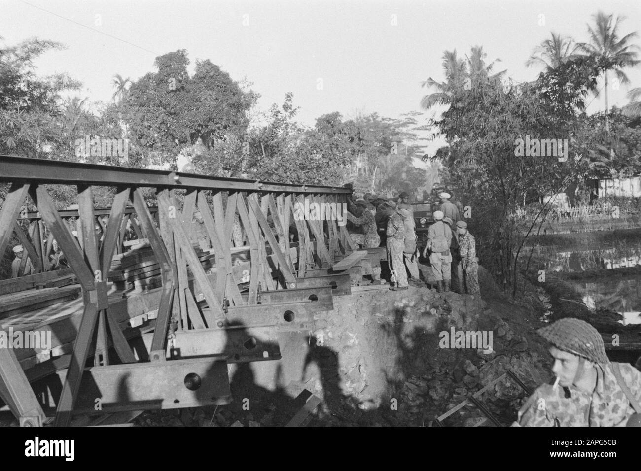 Sektor Cheribon (1. Polizeiaktion 21./27. Juli 1947) Beschreibung: Cheribon-Sektor: Auf ihrer Flucht sprengten republikanische Truppen unzählige große und kleine Brücken hinter sich. Es wurde jedoch vorweggenommen und überall, wo unsere Truppen vor einer zerstörten Brücke standen, wurde von der Genie in kurzer Zeit eine Brücke gebaut. Das Genie baut eine Bailey-Brücke an der Straße nach Cheribon. Datum: 21.Juli 1947 Ort: Cirebon, Indonesien, Niederländisch-Ostindien Stockfoto