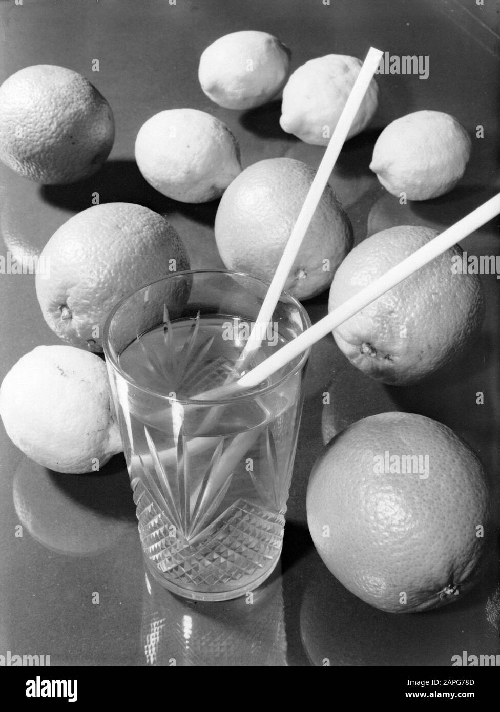 Produktfotos; Glaskunst Beschreibung: Zitrusfrüchte und ein Trinkglas aus gepresstem Glas mit Strohhalmen Datum: Undatierter Ort: Leerdam, Süd-Holland Schlüsselwörter: Zitrusfrüchte, Glaskunst Stockfoto