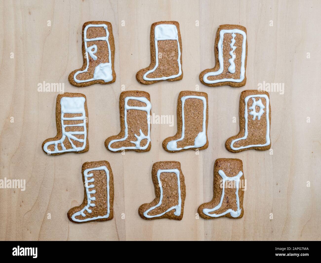 Schuh-förmige Weihnachten Lebkuchen cookies mit weißer Zuckerglasur auf Holz- rustikalen Board geschossen von oben angeordnet Stockfoto