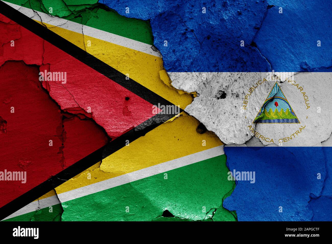 Flaggen von Guyana und Nicaragua auf gerissene Wand gemalt Stockfoto