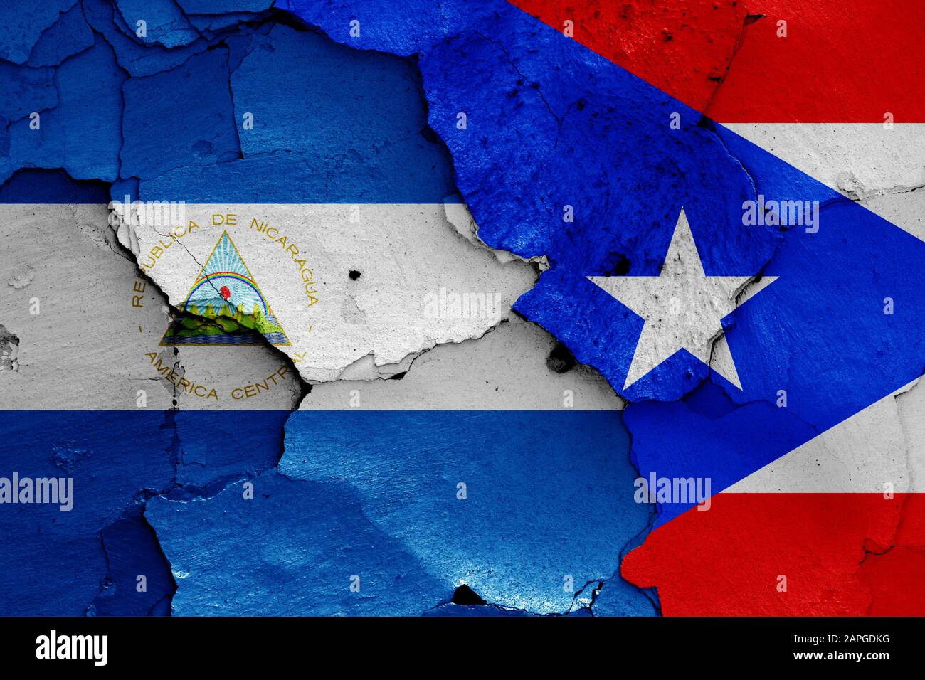 Flaggen von Nicaragua und Puerto Rico auf gerissene Wand gemalt Stockfoto