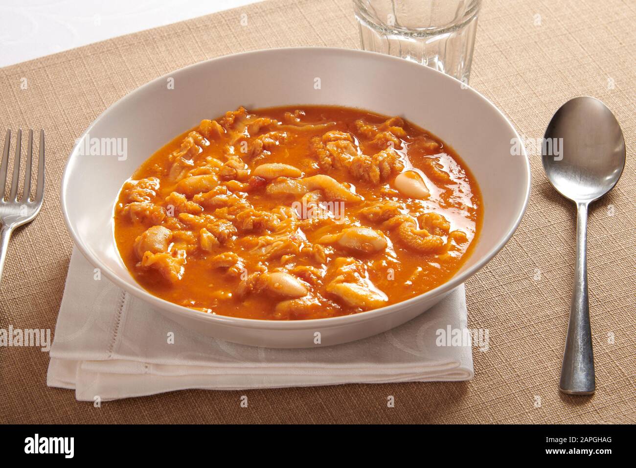 Schüssel mit traditioneller italienischer Trippe oder Magenfutter eines Wiederkäuers in Tomatensauce, serviert am Tisch mit einem Löffel Stockfoto