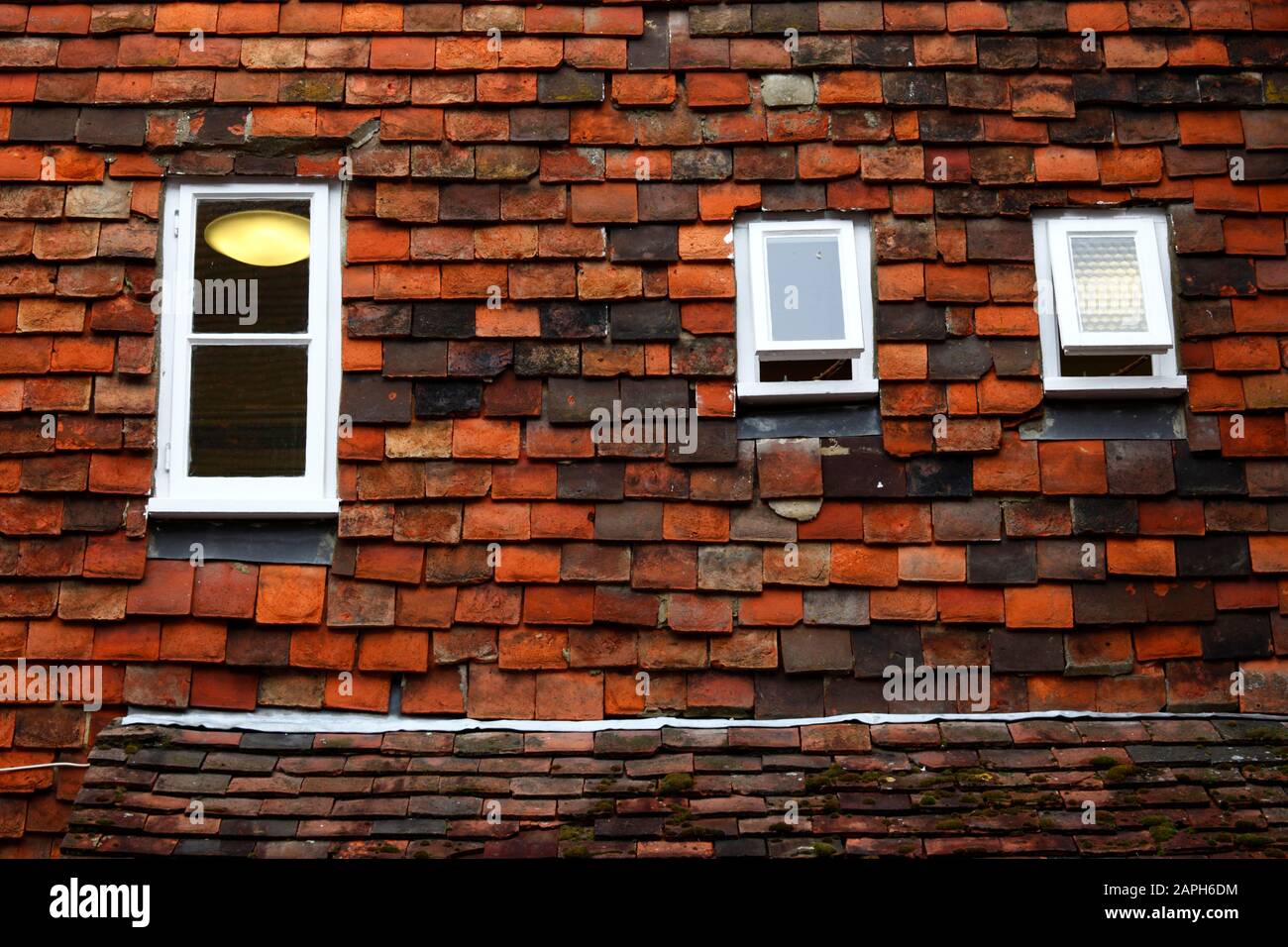 Details zu kleinen Fenstern, die in senkrechte Fliesen (eine typische Bautechnik von Weald of Kent) an der Wand, Tenterden, Kent, England, gesetzt sind Stockfoto