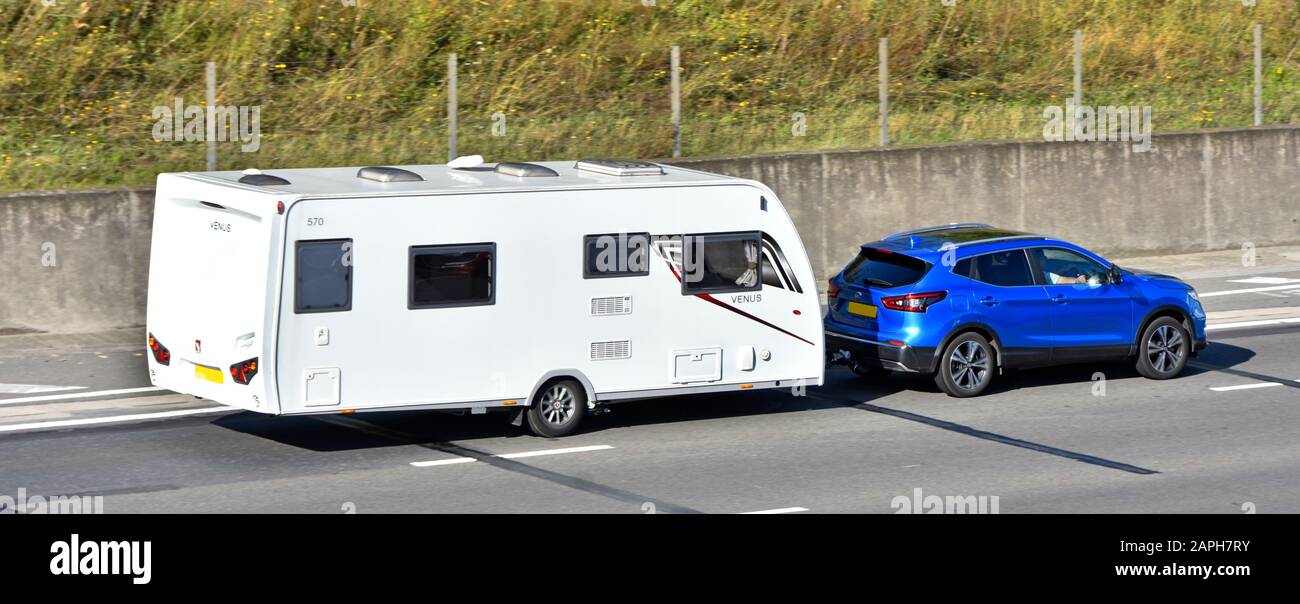 Blick von oben und hinten von Blue Nissan Hatchback Auto & Fahrer mit weißem Lunar Venus 570 Urlaub Caravan Fahren auf der Autobahn M25 England Großbritannien Stockfoto