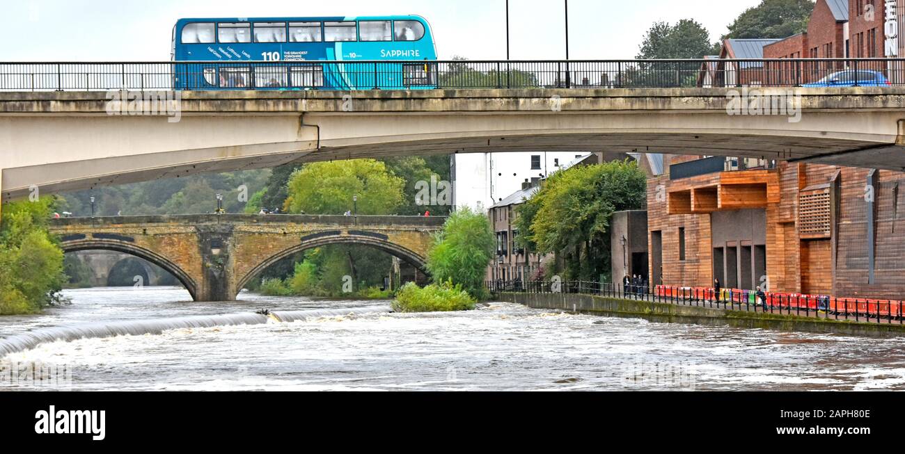 Betonbrücke und Bus über turbulenter Flutströmung River Tragen nach starken Sommerregen historischen Bogen Framwellgate Bridge jenseits von Durham England UK Stockfoto