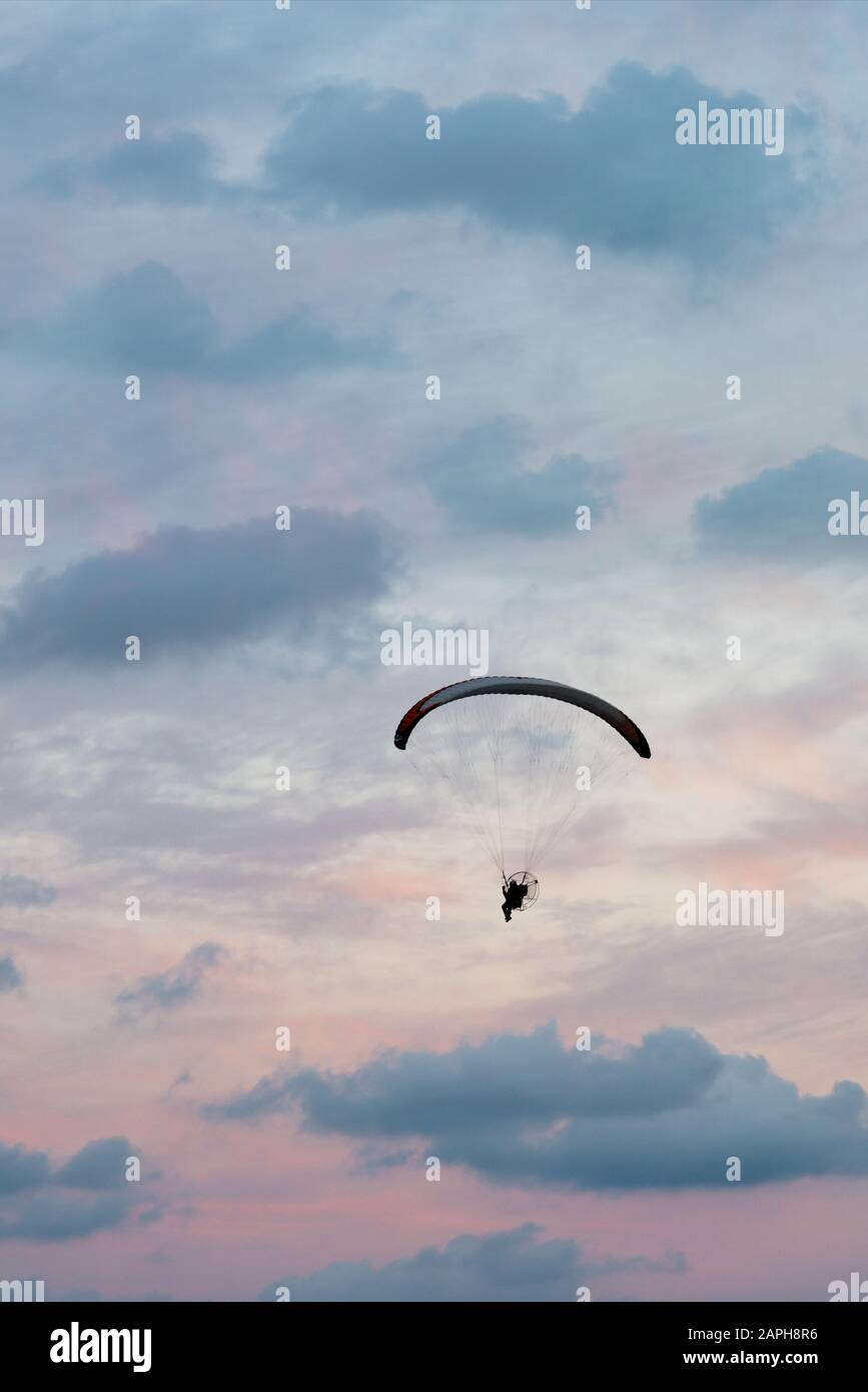 Paramotorflug in vertikalem Himmel bei Sonnenuntergang Stockfoto