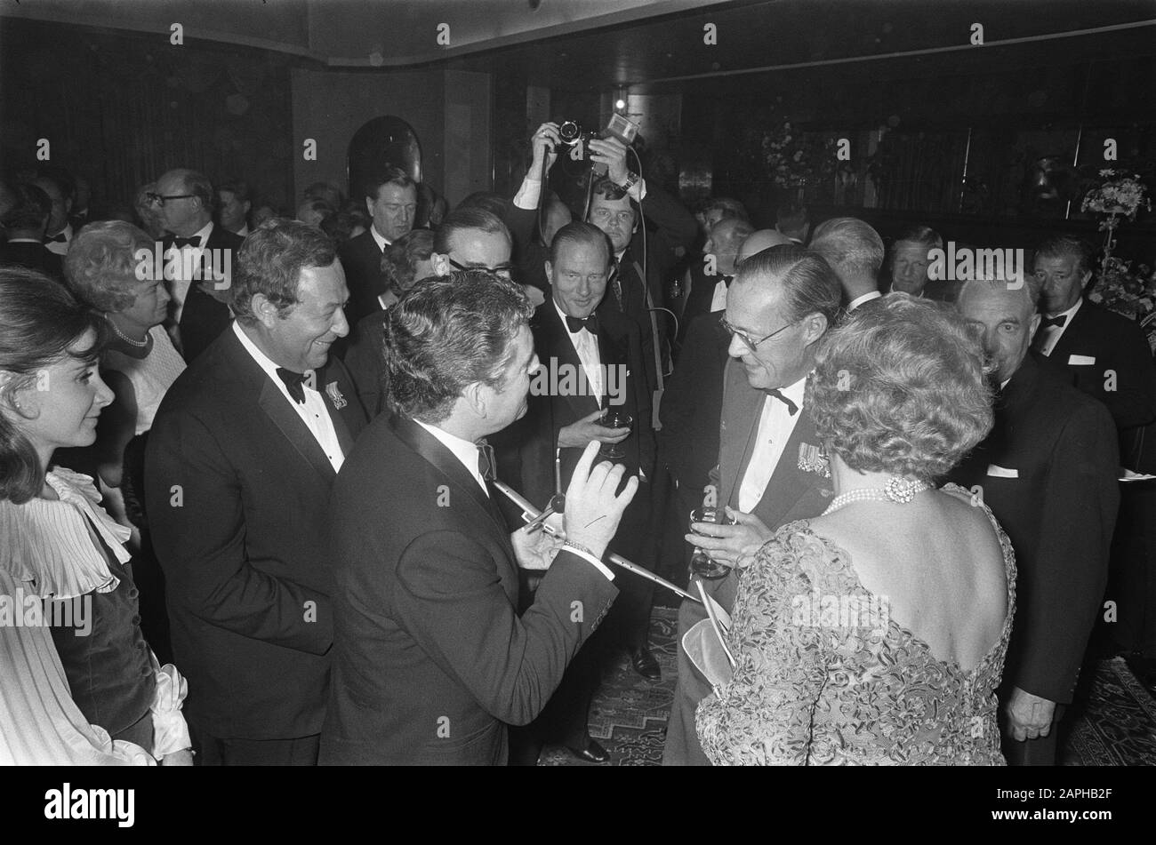 Königin Juliana und Prinz Bernhard nehmen an der niederländischen Galapremiere des Films Battle of Britain im Tuschinski Theater in Amsterdam Teil Beschreibung: Der englische Schauspieler Kenneth More im Gespräch mit Prinz Bernhard und Königin - Juliana. - Ja. In seiner Hand ein Modell einer Spitfire Datum: 25. September 1969 Ort: Amsterdam, Noord-Holland Schlüsselwörter: Schauspieler, Blumen, Filme, Königinnen, Premieren, Theater persönlicher Name: Bernhard (Prinz Niederlande), Juliana (Königin Niederlande), Mehr, Kenneth Stockfoto