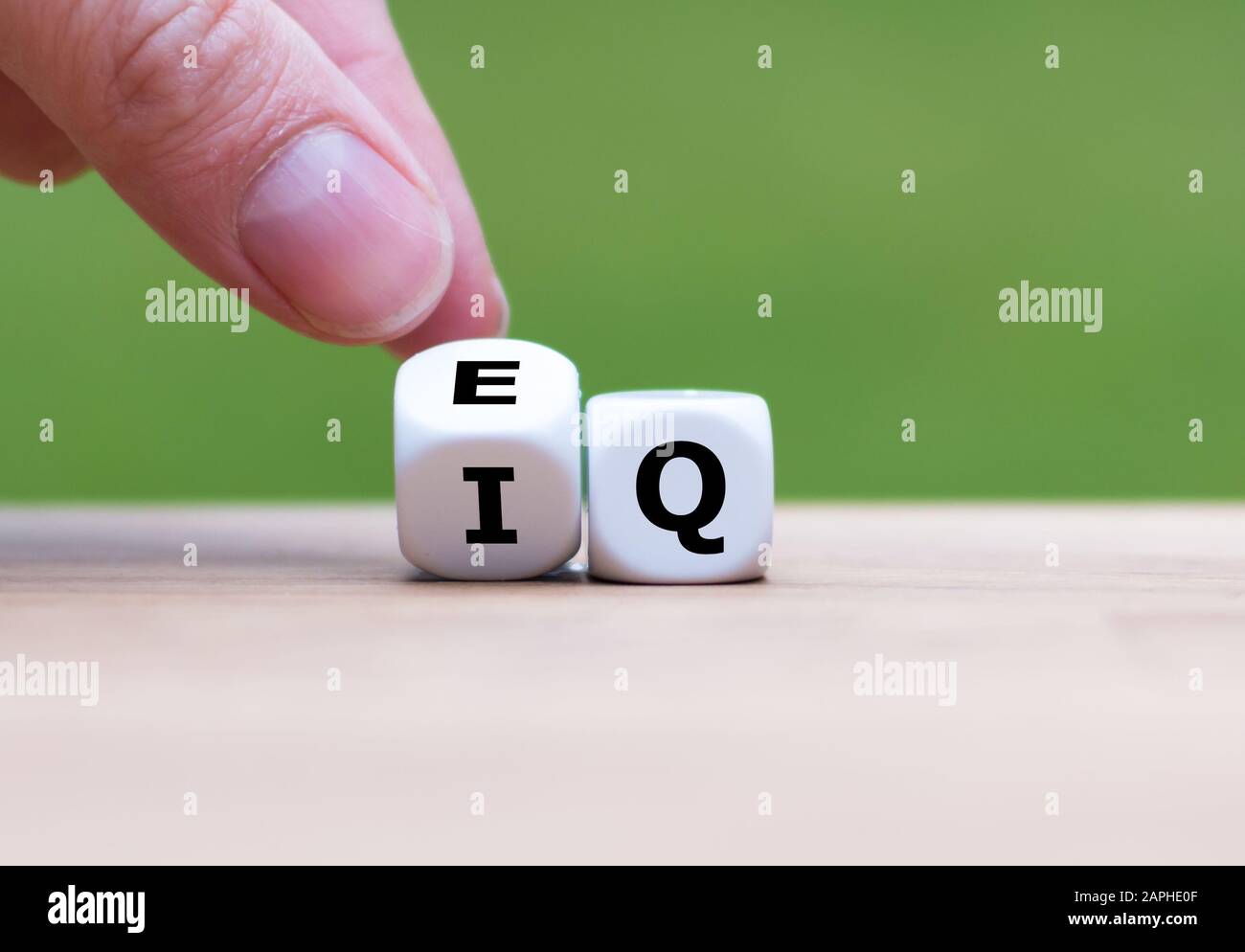 Hand dreht einen Würfel und ändert den Ausdruck "IQ" (Intelligenzquotient) in "EQ" (Emotionale Intelligenz/Quotient). Stockfoto