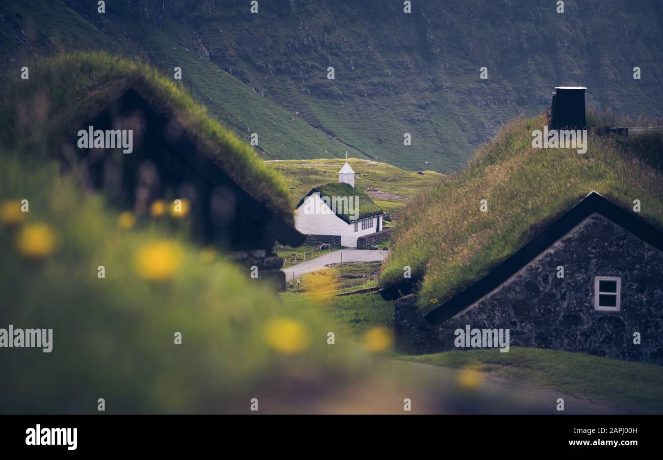 Dúvugarðar, der alte Bauernhof im Dorf Saksun. Im Hintergrund die Kirche mit dem typischen Rasendach. Färöer Stockfoto