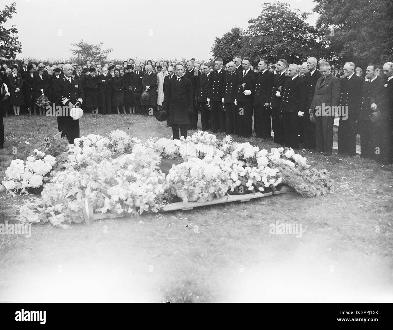Bestattung der Hinterbij-Nacht D.C.M. Hetterschij auf dem dortigen Generalfriedhof Rhenen am Achterbergsestraatweg. Hinter den Blumenkränzen, links mit weißer Kappe in den Händen, der Kommandeur der Seestreitkräfte, Admiral C.E.L. Helfrich. Rechts neben ihm der Unterführer F. van Hernen. Recht, Deputationen der niederländischen und belgischen Lotsendienste Datum: 9. September 1948 Ort: Rhenen Schlüsselwörter: Beerdigungen, Marine, Offiziere Personenname: Helfrich C E L, Hernen F van, Hetterschij D C M Stockfoto