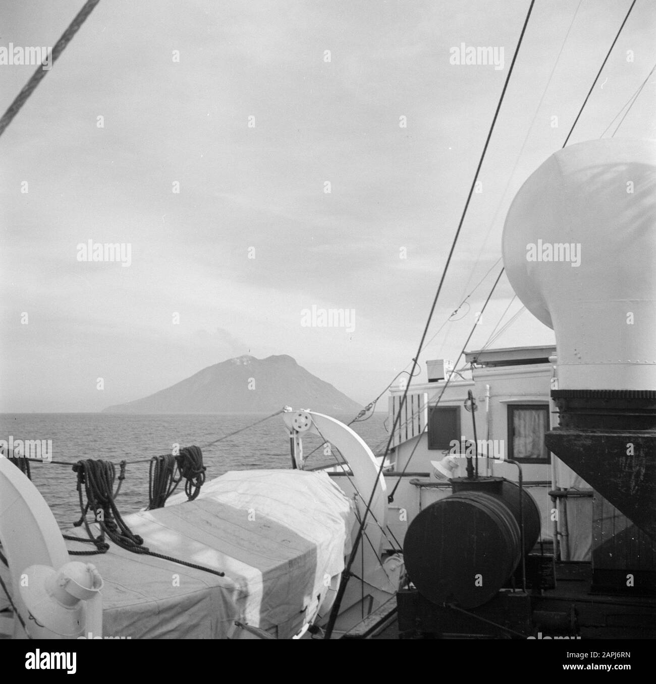 Israel 1948-1949: Seefahrt Beschreibung: Teil eines Schiffsdecks mit einem Vulkan am Horizont, möglicherweise die Stromboli Anmerkung: Fotograf Willem van de Poll machte diese Aufnahme an Bord des Schiffes, mit dem er 1948 von Genua nach Haifa (Israel) reiste Datum: 1948 Ort: Italien, Stromboli Schlüsselwörter: Rettungsboote, Schiffahrt, Schiffe, Vulkane Stockfoto