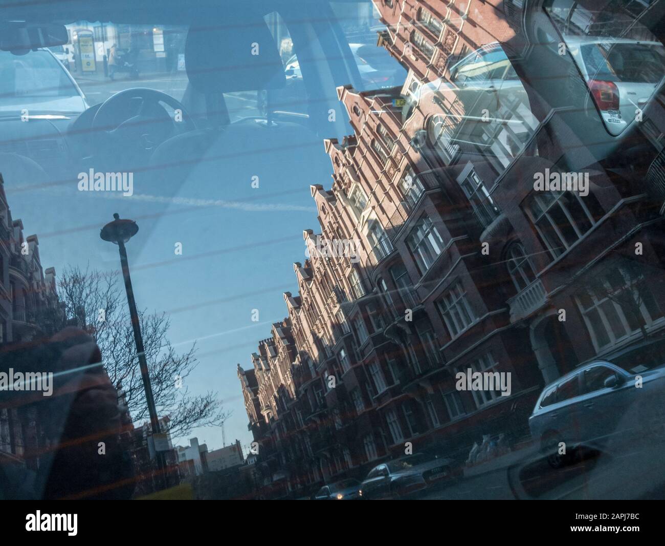 Reflexionen von Herrenhausblöcken in der Cabbell Street W1 in der Heckscheibe eines geparkten Hatchback-Wagens. Metapher für den Immobilienmarkt in London. SIEHE HINWEISE. Stockfoto