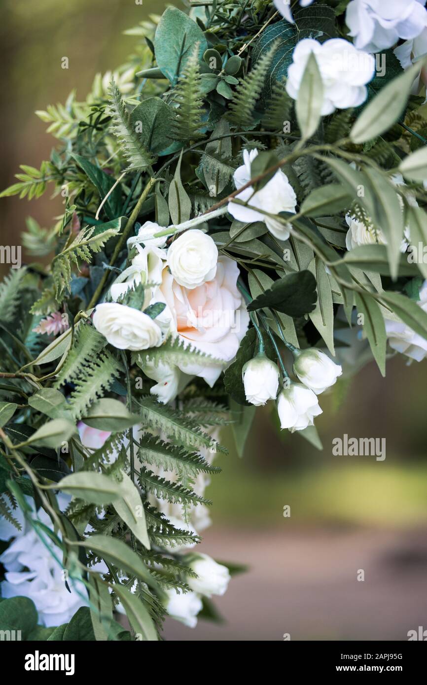 Wunderschöne weiße Blumen auf einem metallenen Hochzeitsbogen für die Hochzeit im Freien Stockfoto