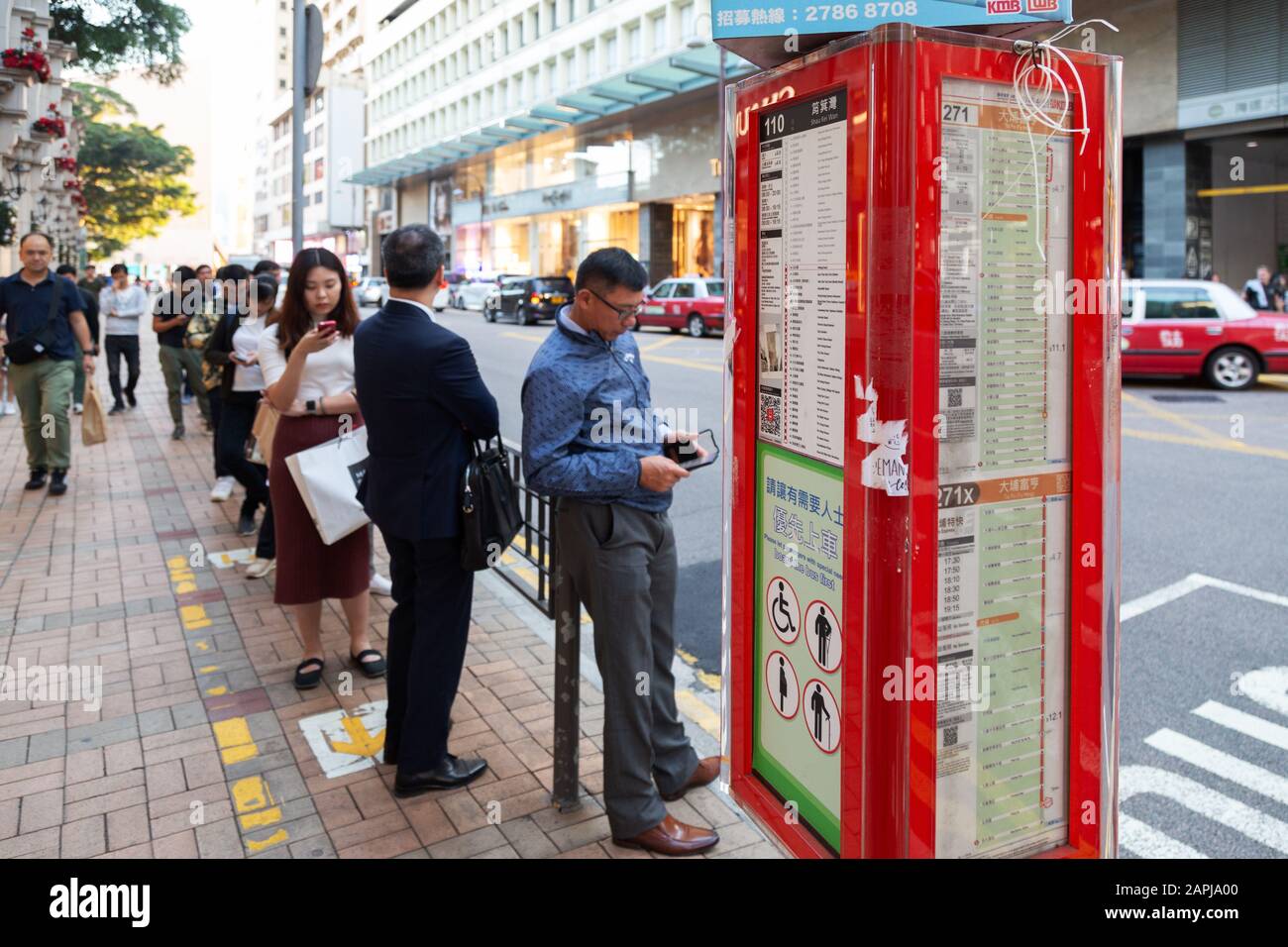 Hongkong Lifestyle - Menschen, die an einer Bushaltestelle auf einen Bus an einer Bushaltestelle in Hongkong Asia warten Stockfoto