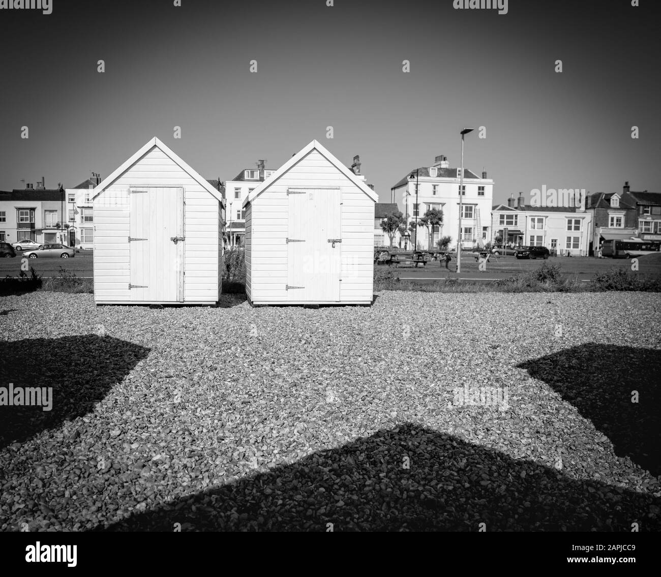 Zwei weiße Strandschuppen mit Schatten, die auf Dem Niedrigen Punkt der Hafengegend Hineinführen Stockfoto