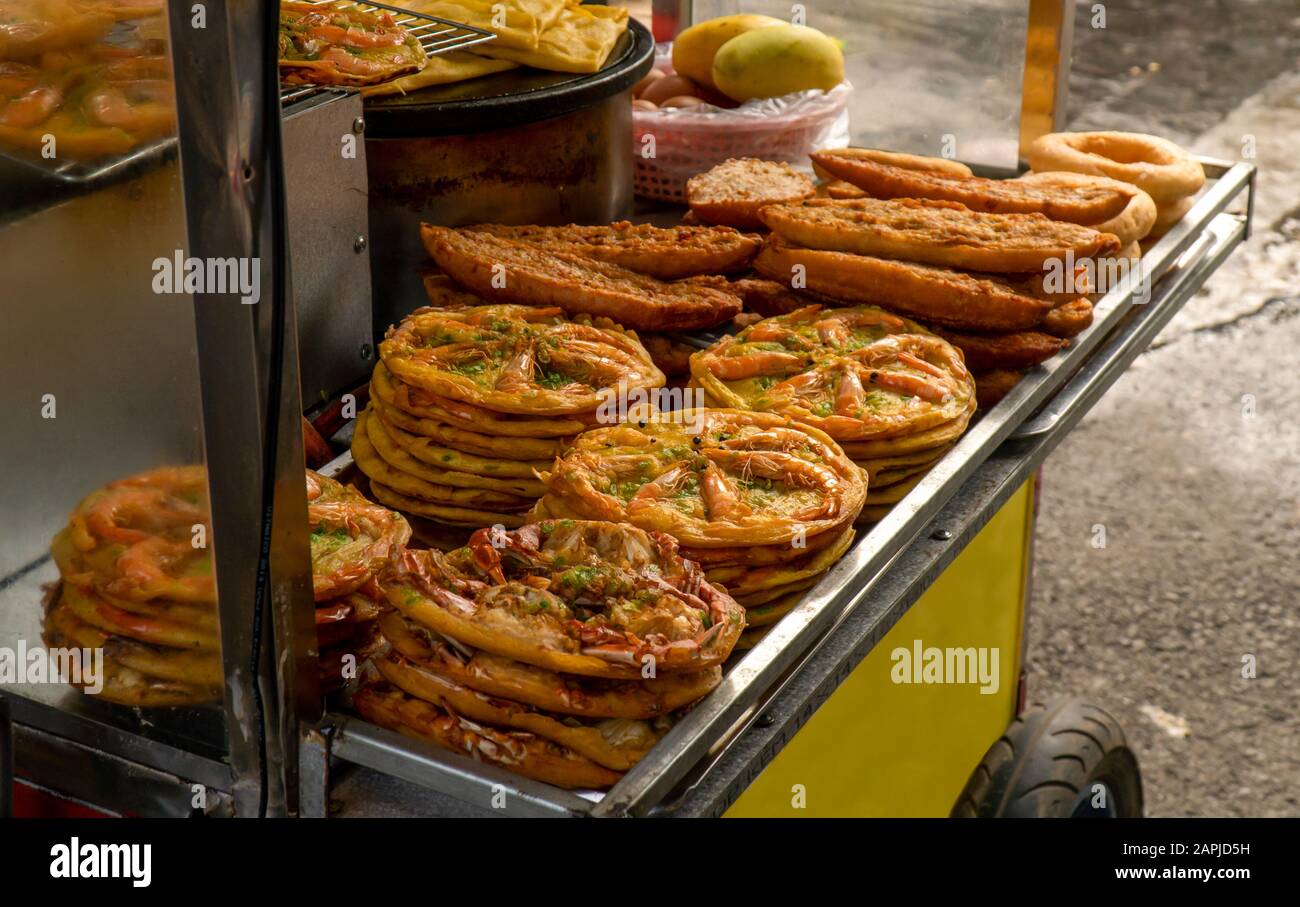 Banh Xeo wurde vom Straßenhändler Hoi An auf einem Lebensmittelwagen serviert. Banh Xeo ähnelt einer Pfannkuchen oder Kreppe, die normalerweise mit Garnelen, Schweinefleisch und Bohnensprossen serviert wird. Stockfoto