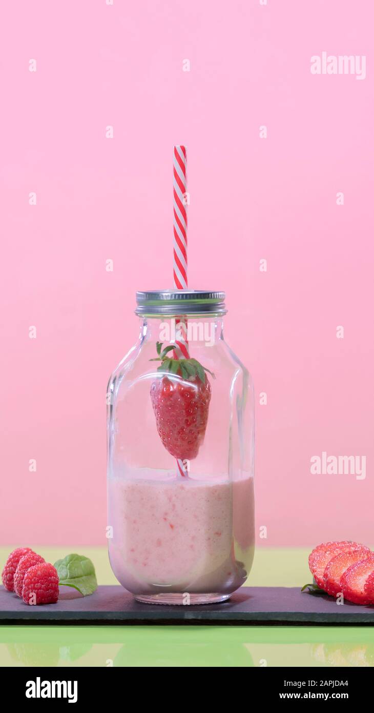 Schmackhaft aussehender Erdbeer-Milchshake in einem Glasflaschenbecher Stockfoto