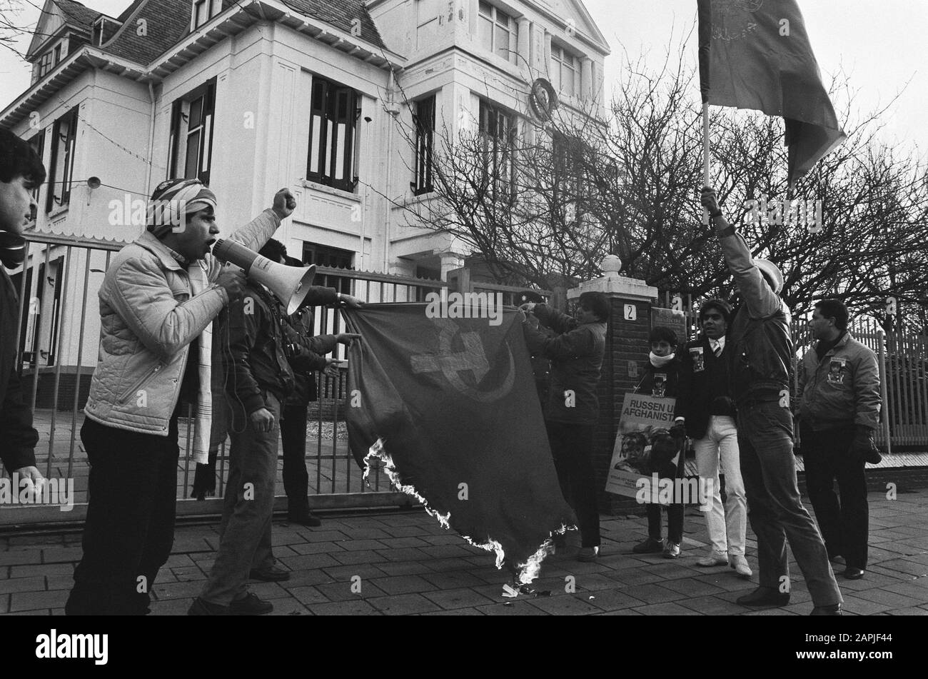 Afghanen, die in den Haag gegen die russische Präsenz in Afghanistan demonstrieren Beschreibung: Demonstranten verbrennen die sowjetischen Flaggen Datum: 27. Dezember 1985 Ort: Den Haag, Süd-Holland Schlüsselwörter: Embassaden, Demonstrationen, Demonstranten, Flaggen, Flaggen Verbrennungen der Flagge Stockfoto