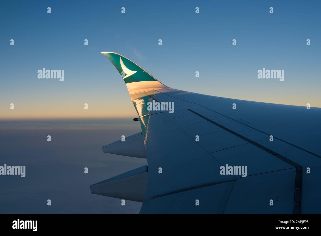 Der Sonnenuntergang scheint auf der Flügelstürze eines airbus A350-1000 von Cathay Pacific Stockfoto