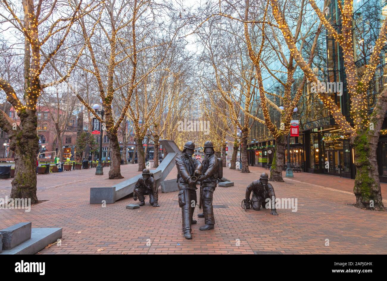 Bronzeplastiken von Hai Ying Wu für das Denkmal Der Gefallenen Feuerwehrleute im Occidental Park, Pioneer Square, Seattle, Washington, während der Ferienzeit. Stockfoto