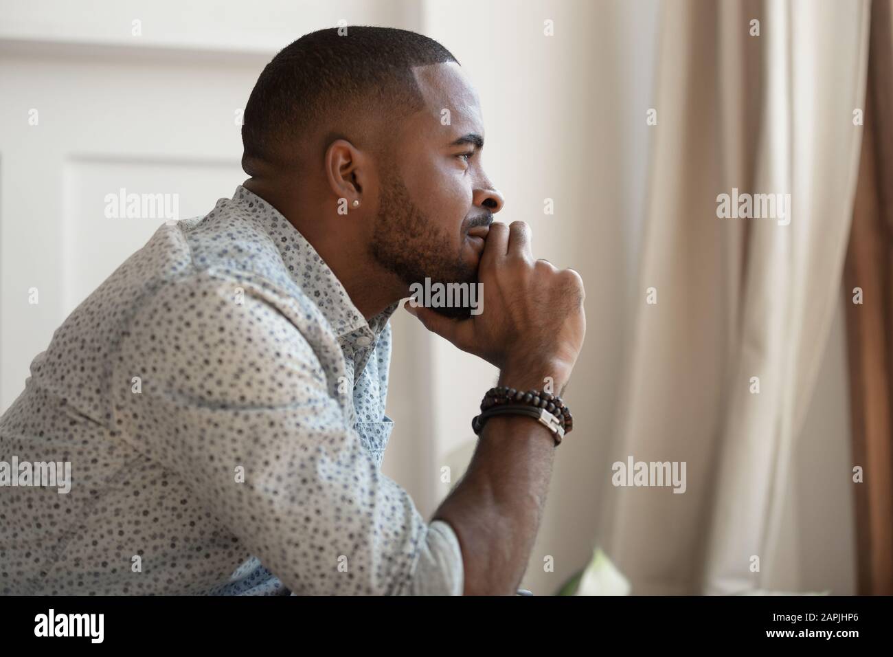 Nahansicht der afrikanische Typ berührt Kinn denkt wegschauen Stockfoto