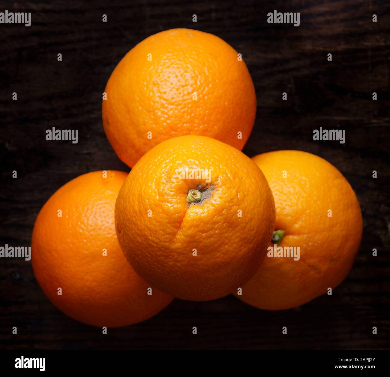 Anordnung ganzer Orangen auf dunklem Hintergrund. Kleine Gruppe von Objekten. Stockfoto