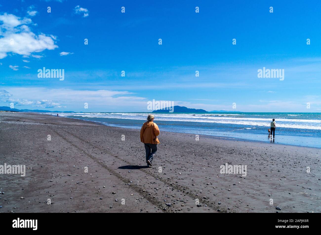 Insel Kāpiti vom Strand Ōtaki aus gesehen, mit Mann und Frau, Nordinsel, Neuseeland Stockfoto