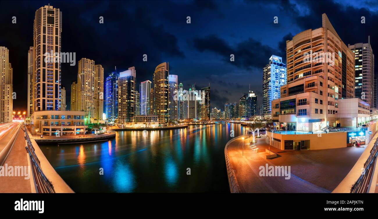 Dubai Marina in der Nacht, mit der Skyline und bunten Lichtreflexionen auf dem Wasser Stockfoto