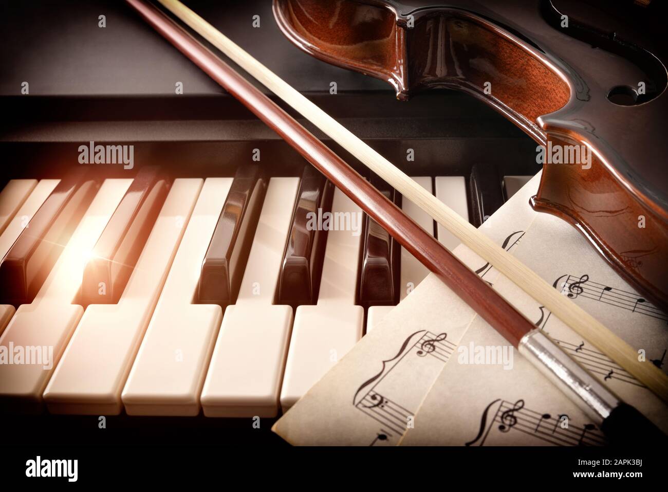 Geigenbogen und Noten auf Klaviertasten. Konzept der Interpretation von Klaviermusik und Streichinstrumenten. Vorderansicht. Horizontale Zusammensetzung. Stockfoto