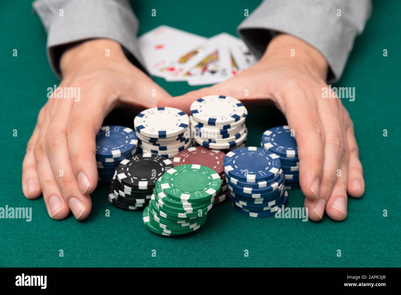 Man spielt Poker im Casino. Mann sammeln Stapel von Poker chips, Glücksspiel Konzept. Stockfoto