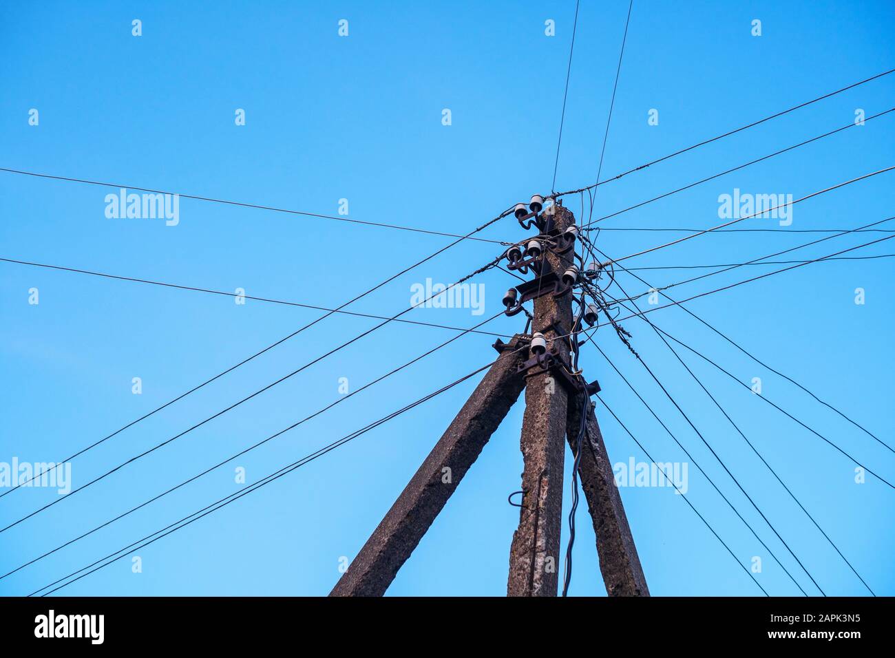 Stange mit Drähten gegen den Himmel. Hintergrund des Stromnetzes Stockfoto
