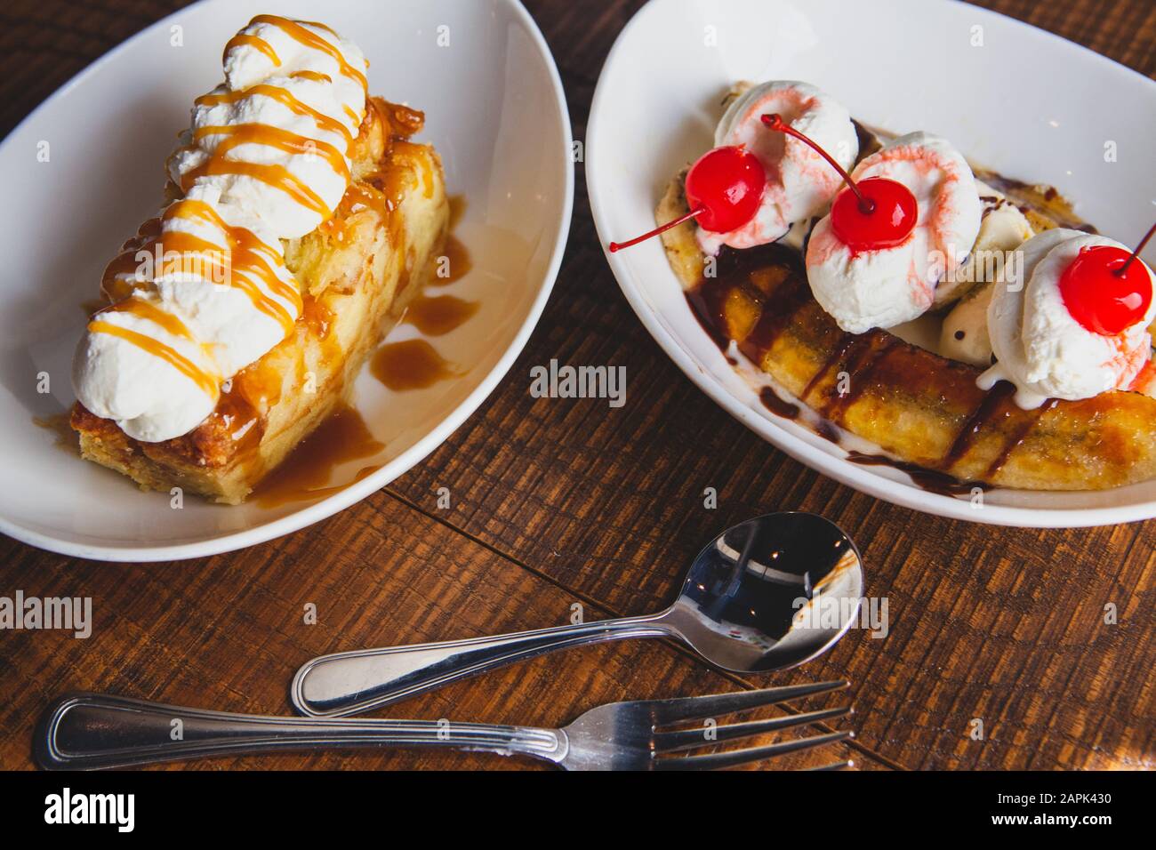 Banana Split mit Kirschen und Brotpudding Desserts sitzen auf einem Holztisch gekrönt. Stockfoto