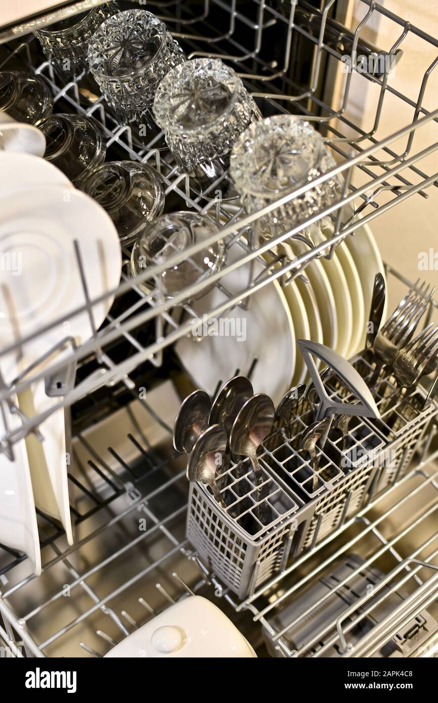 Gewaschene Gerichte in warmem Licht in ausgebauten Geschirrkörben im Winkel. Stockfoto