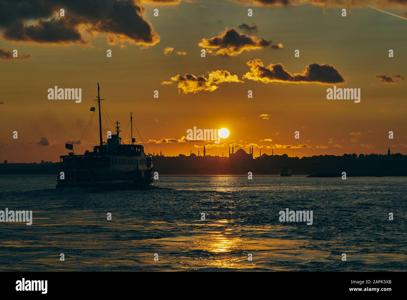 Schöne Sonnenuntergangszeit im Bosporus. Panorama-Sonnenuntergang mit Hagia Sophia, Blaue Moschee, Fähre (Vapur) und Möwen in Istanbul, Türkei. Stockfoto