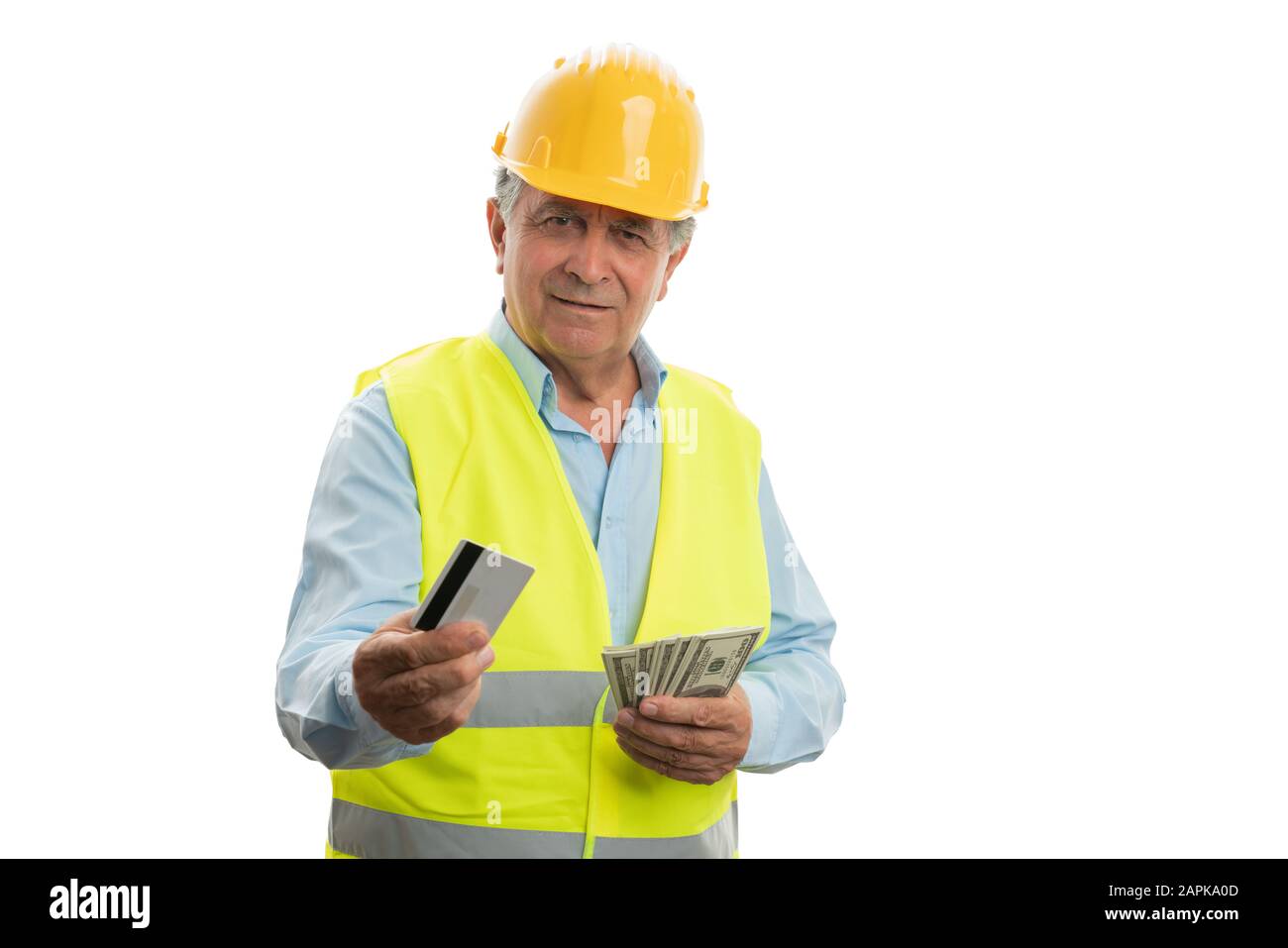 Der alte lächelnde, männliche Architekt, der Karten- und Dollarscheine mit freundlichem Ausdruck auf weißem Hintergrund präsentiert Stockfoto
