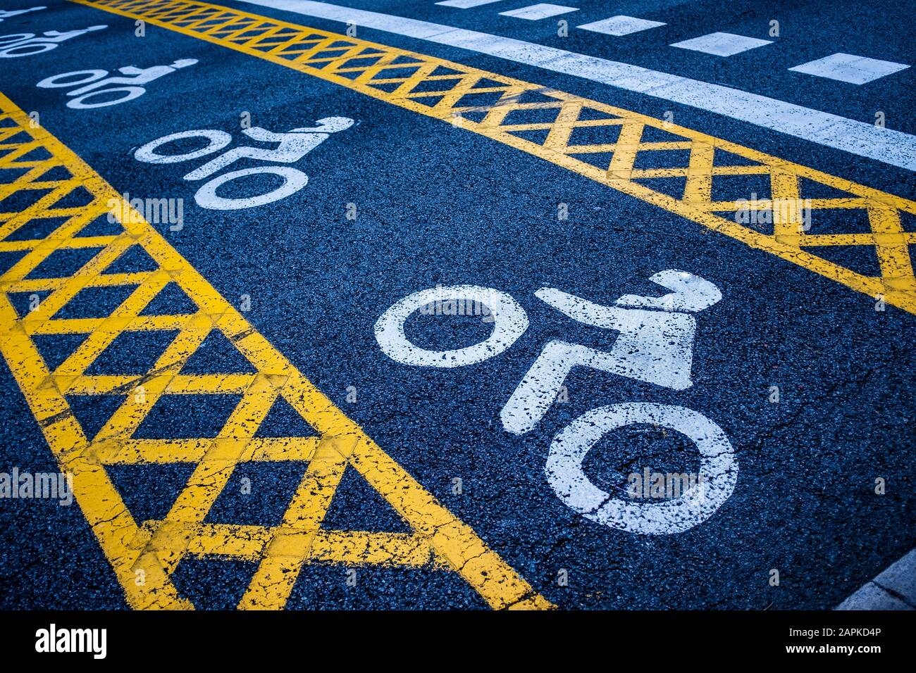 Horizontale Straßenbeschilderung an einer Kreuzung mit Ampeln: In einer Straße wurde ein erweiterter Parkplatz für Motorradfahrer eingerichtet. Stockfoto