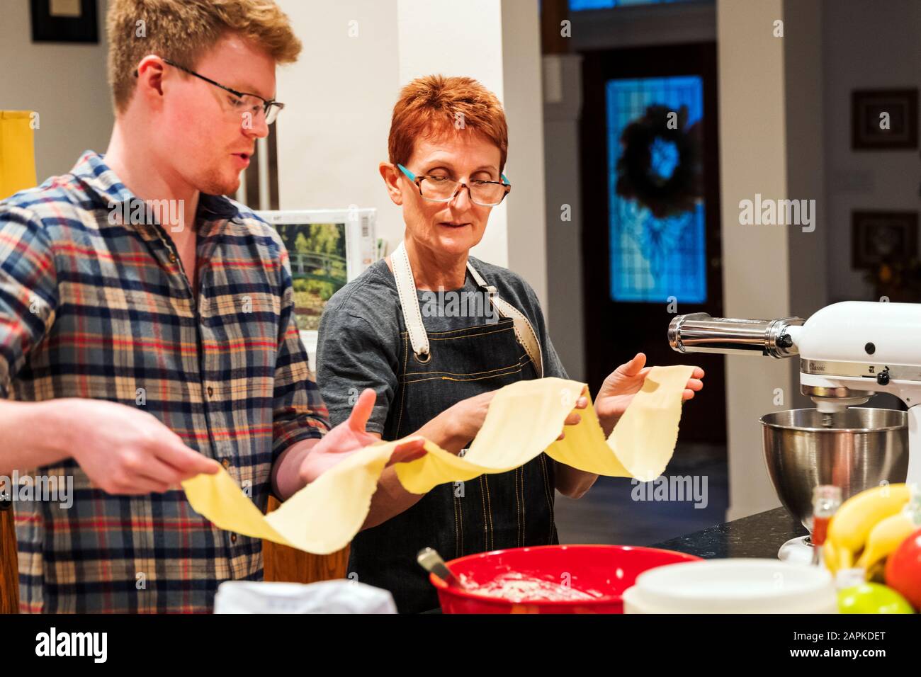 Mutter und erwachsener Sohn bereiten hausgemachte Pasta zu Stockfoto