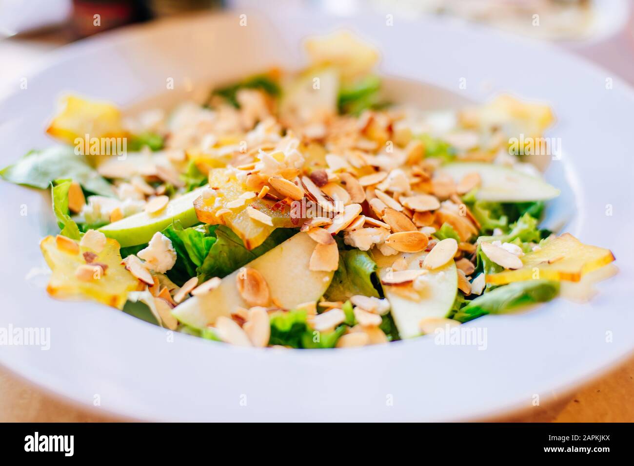 Salat mit Äpfeln, Mandeln und Kräutern im Restaurant Stockfoto