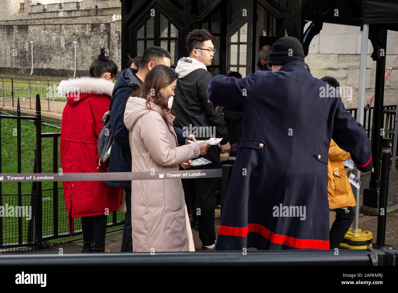 Touristen und ein Beefeater am Eingang des Tower of London Tickets per Smartphone prüfen, London, Großbritannien Stockfoto