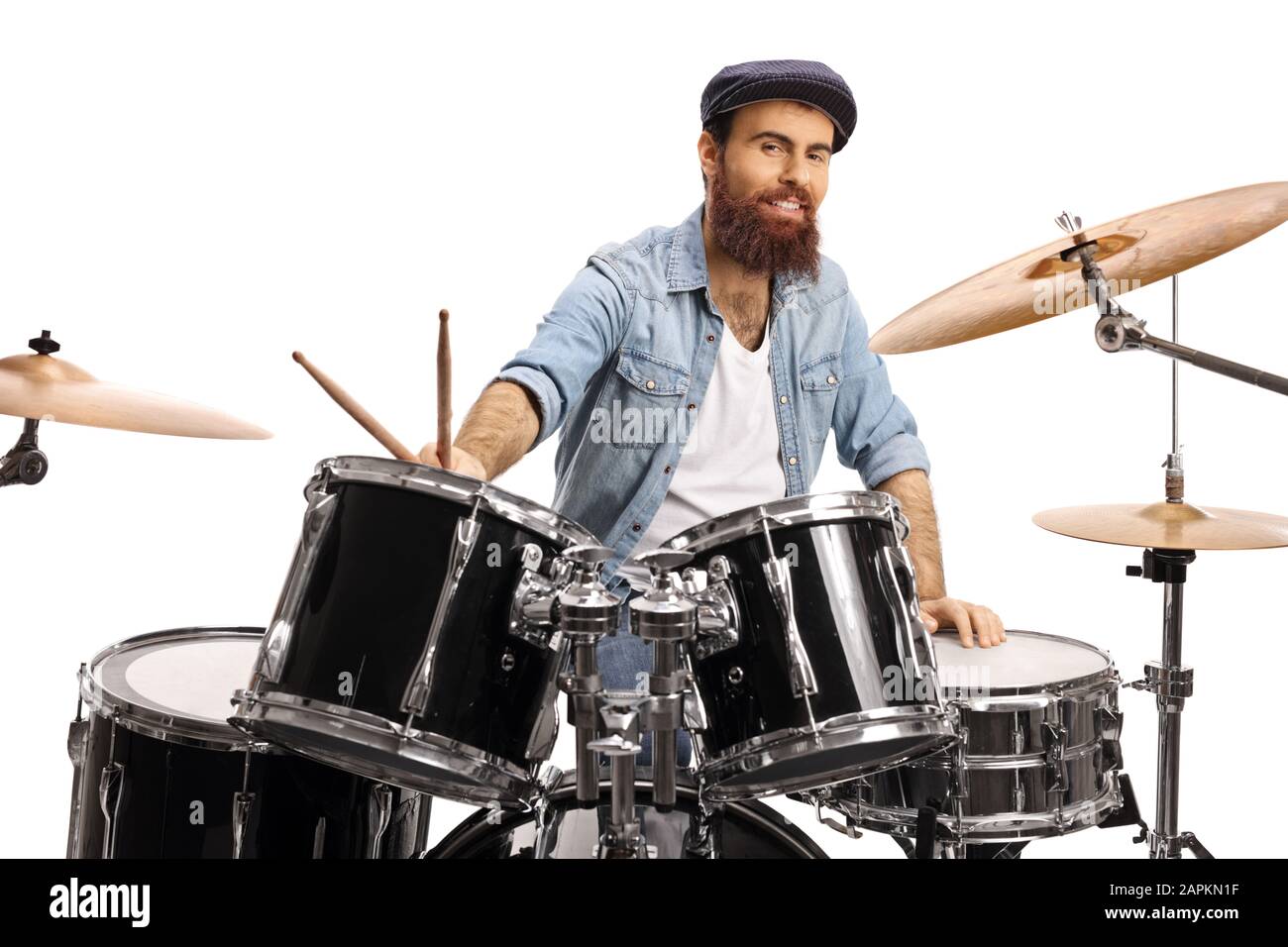 Bärtiger Drummer mit einem auf weißem Hintergrund isolierten Trommelsatz, das an der Kamera lächelt Stockfoto