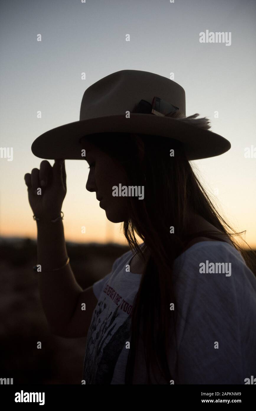 Eine Frau in ihrem geliebten Cowboyhut erkundet den Sonnenuntergang in Joshua Tree Stockfoto