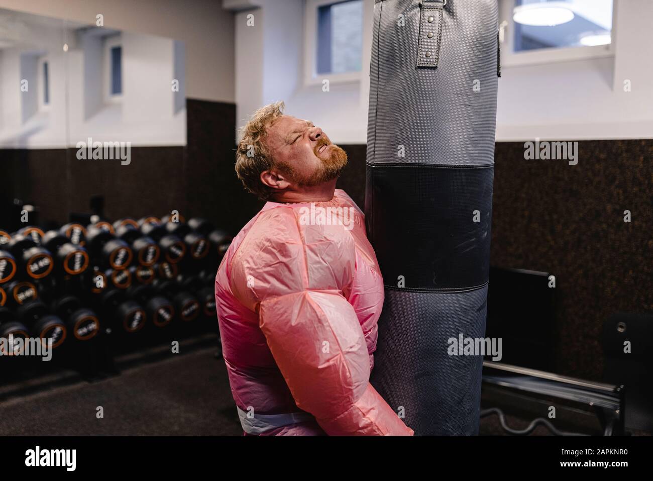 Mann mit pinkfarbenem Bodybuilder-Kostüm in der Sporthalle Stockfoto