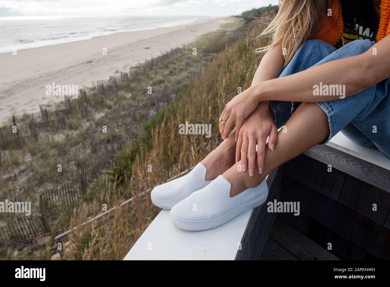 Eine gemütliche Frau blickt auf die atemberaubende Aussicht entlang der Küste Stockfoto