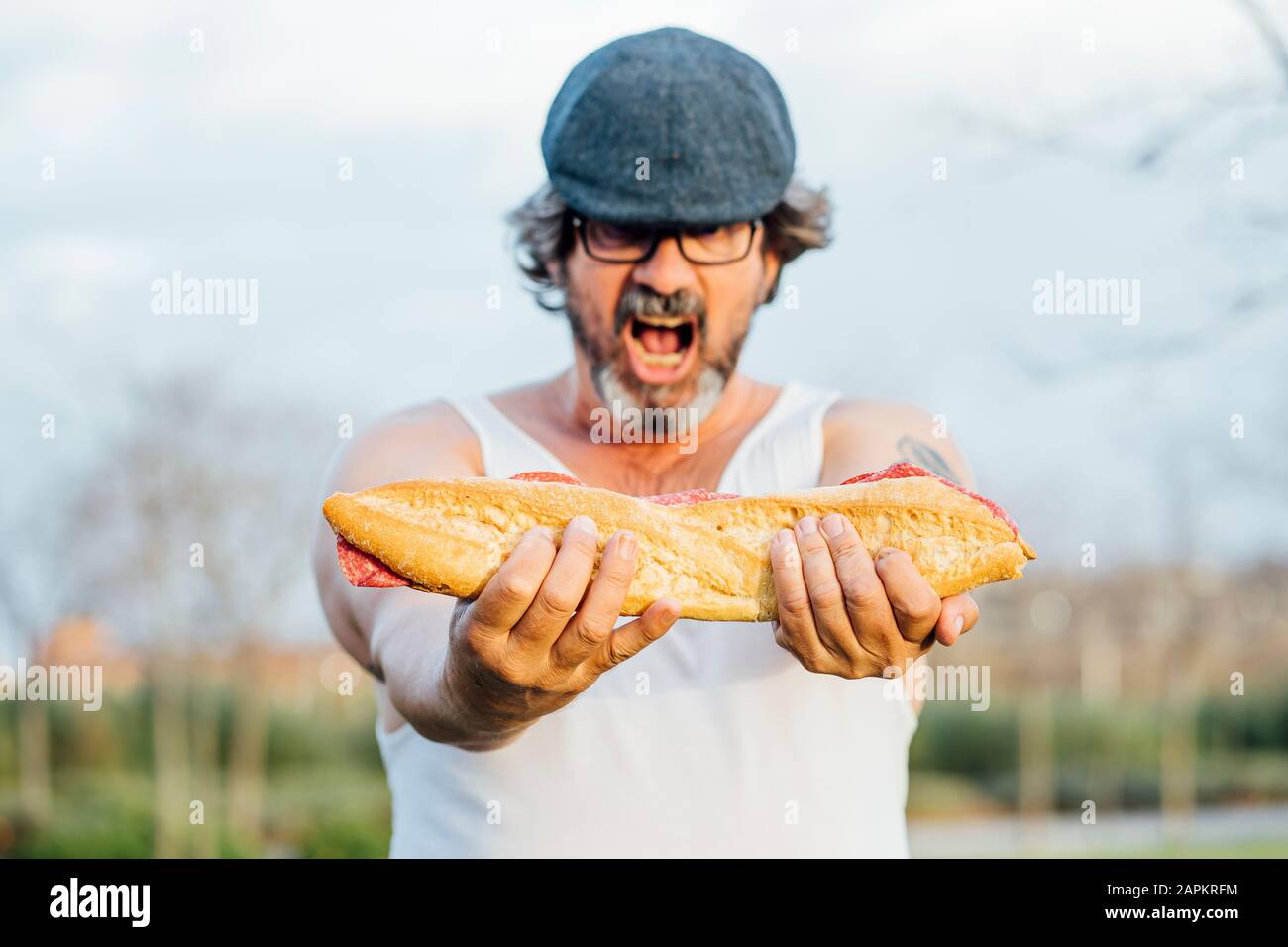 Mann hält Sandwich und schreit Stockfoto