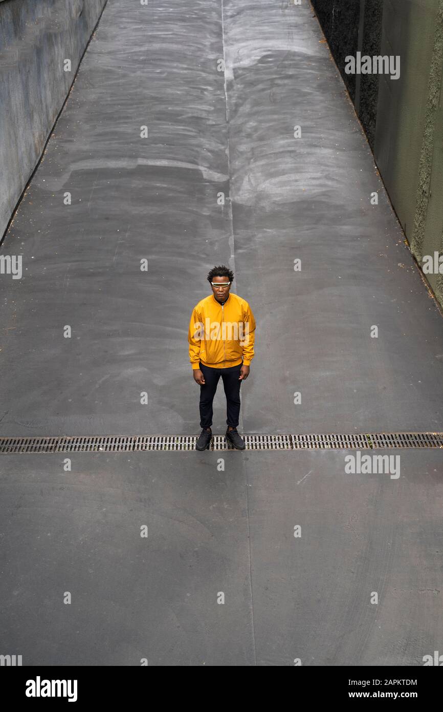 Reifer Mann, der gelbe Jacke trägt und auf der Fahrspur steht Stockfoto