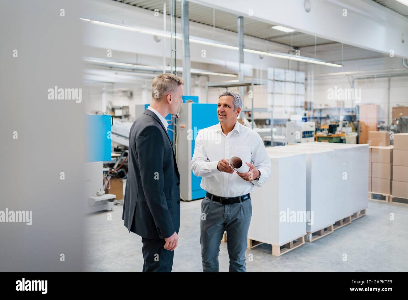 Zwei Geschäftsleute sprechen in einer Fabrik Stockfoto